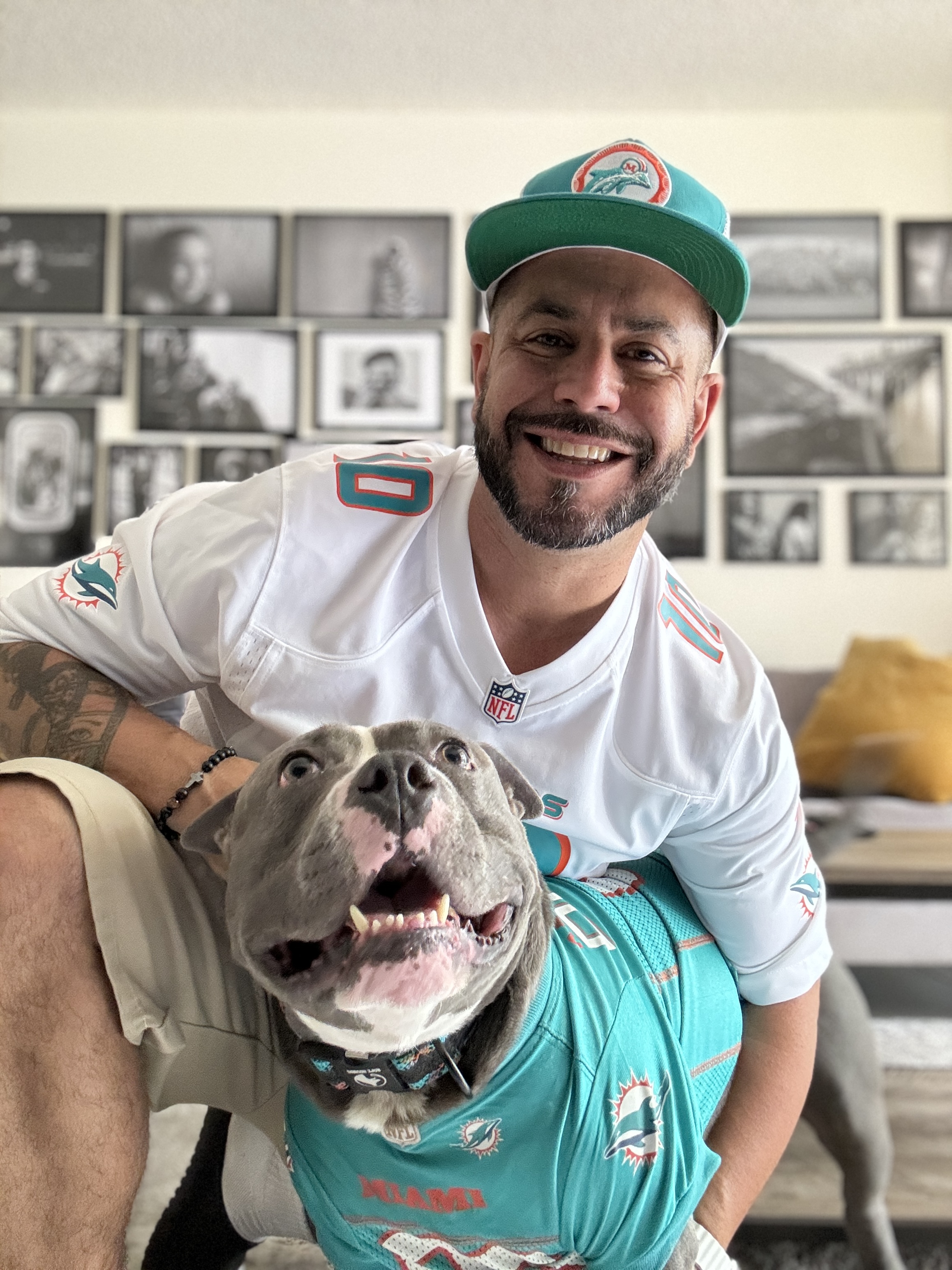 Mike Garcia with his dog Blue, both wearing Miami Dolphins jerseys